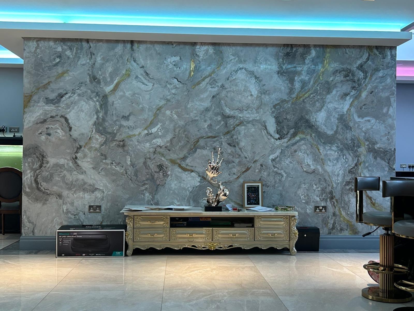 Full-height marble-effect feature wall above a polished porcelain floor in a large open-plan room